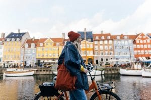 A woman sightseeing with her bike in Copenhagen