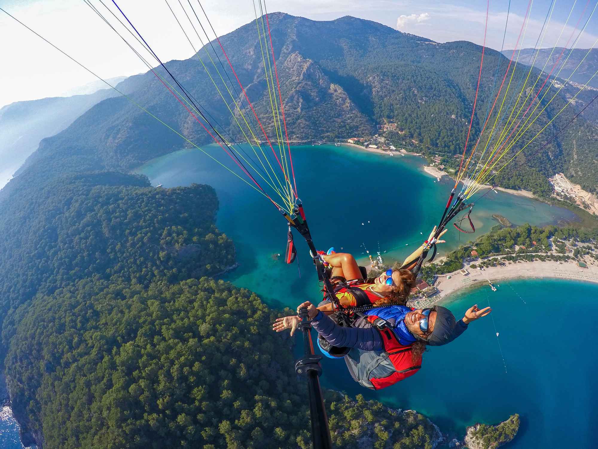 A couple paragliding above stunning landscape