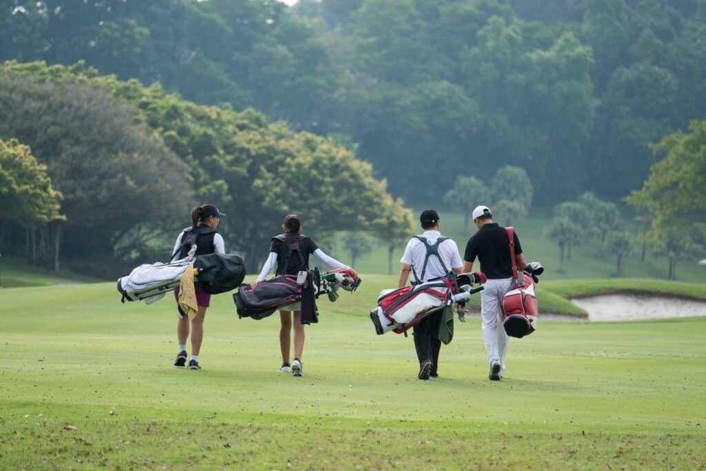 Golfers walking with golf bags 