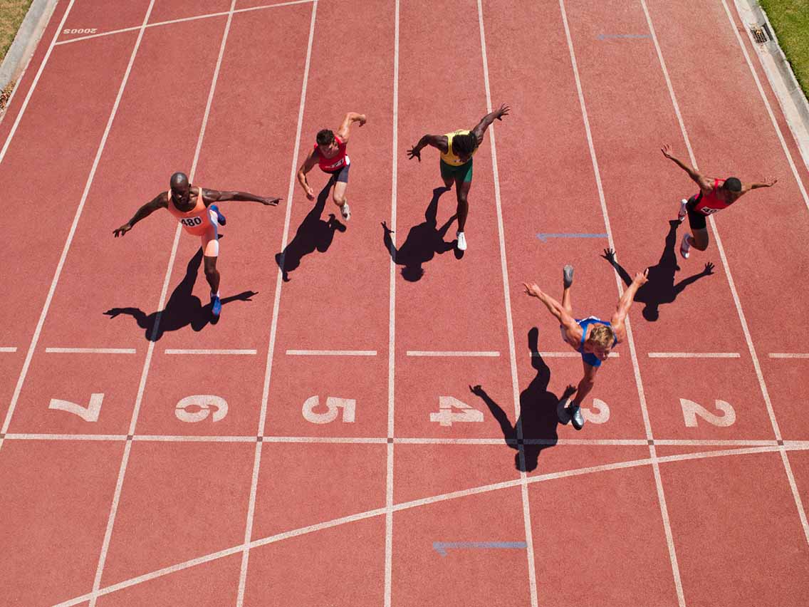 Runners crossing finish line of race track