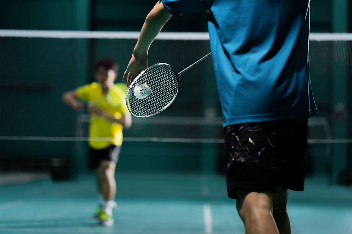 Badminton player ready to serve on court