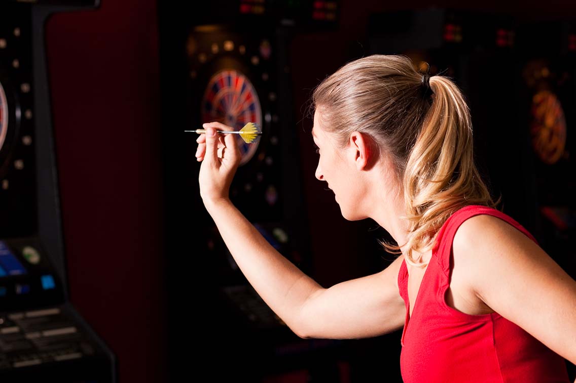 Female player throwing dart