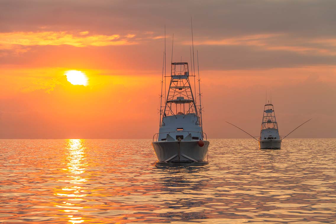 Fishing boats at sea at sunset