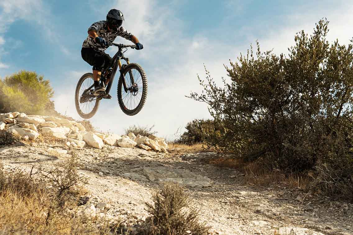 Mountain biker jumping on technical trail