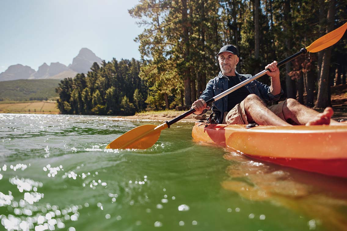Man kayaking on tranquil river in foret setting