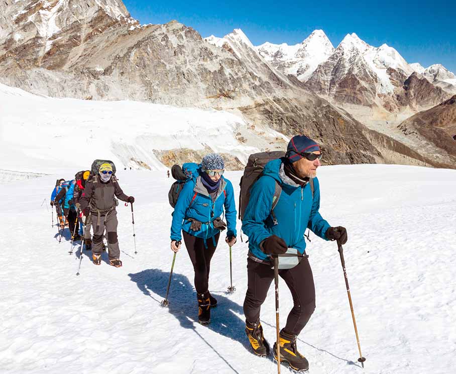 Group of trekkers in Nepal. Hiking on snow with trek equipment