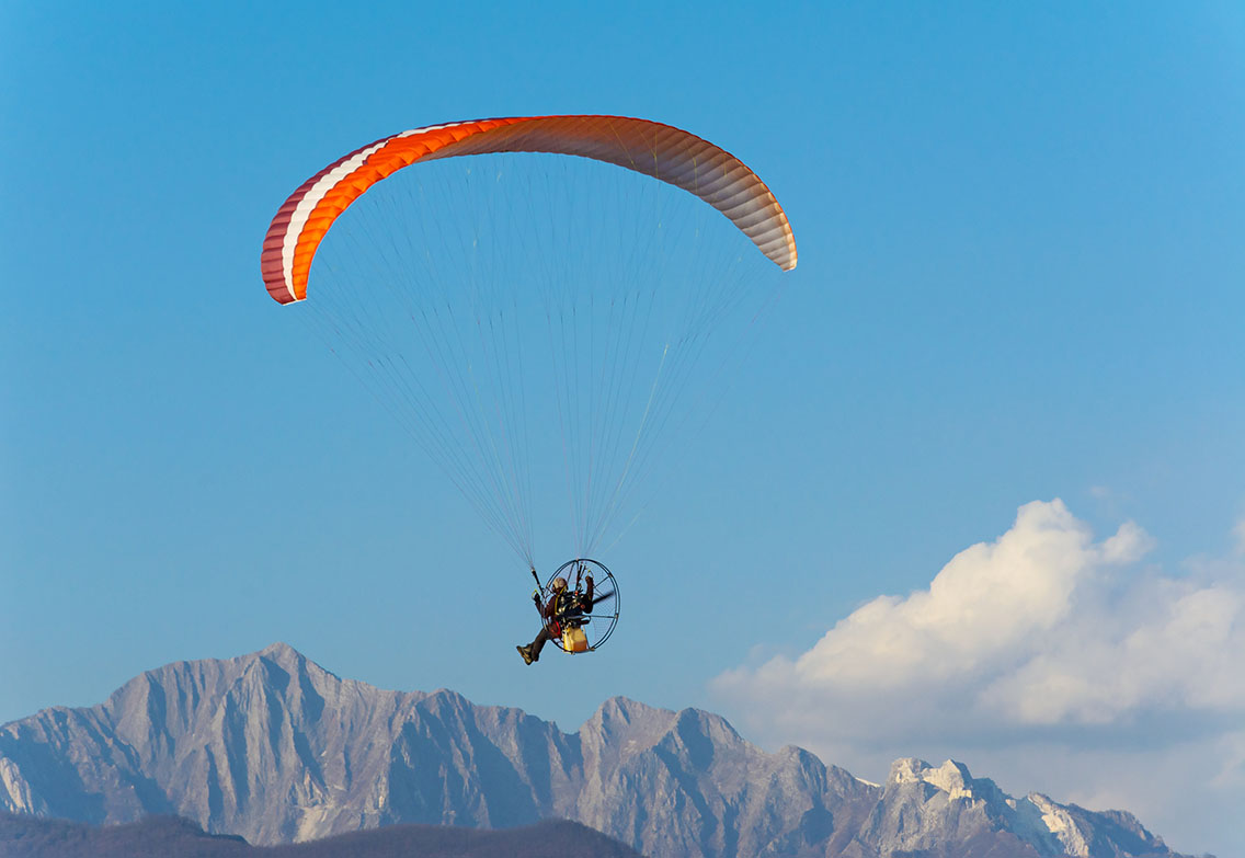Person paramotoring with mountain backdrop