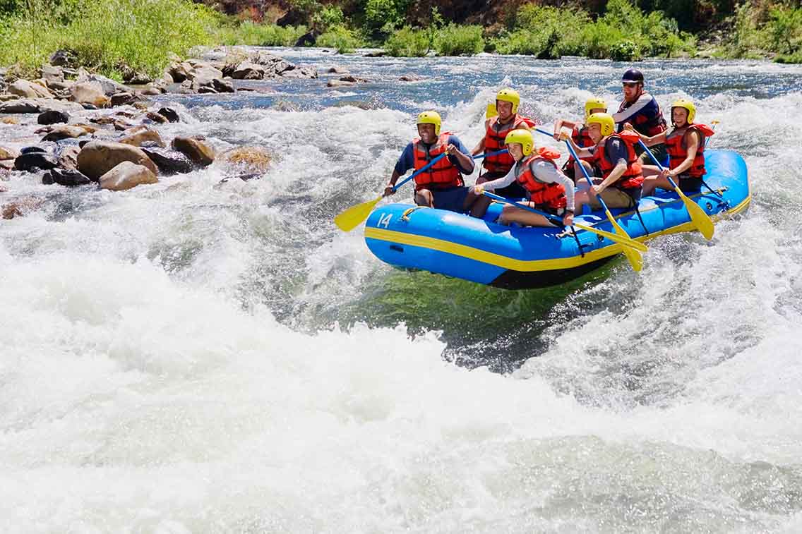 Large raft with people on river rapids