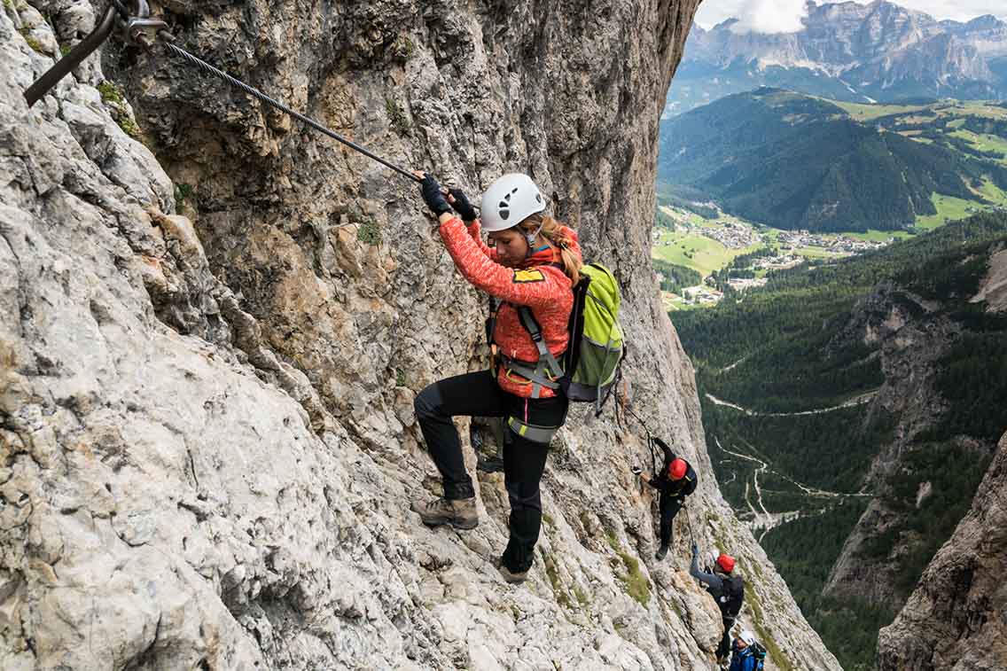 Woman climbing up cliff with ropes