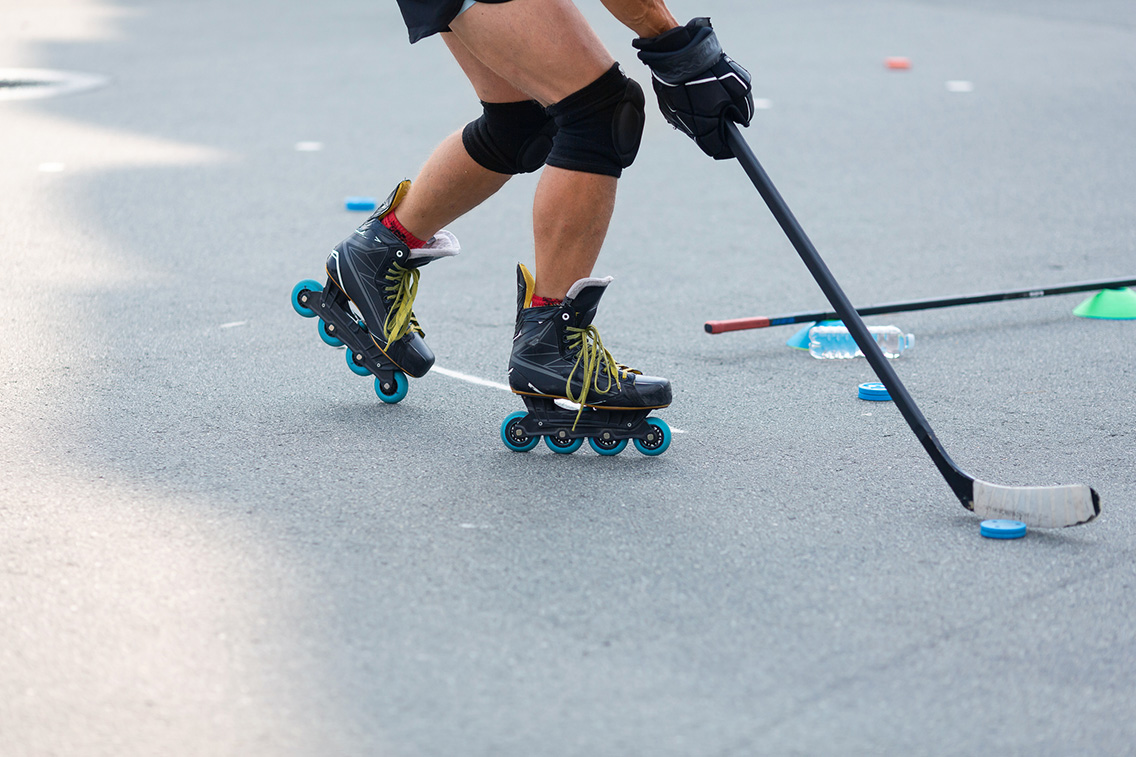 Roller blader with roller hockey stick and ball
