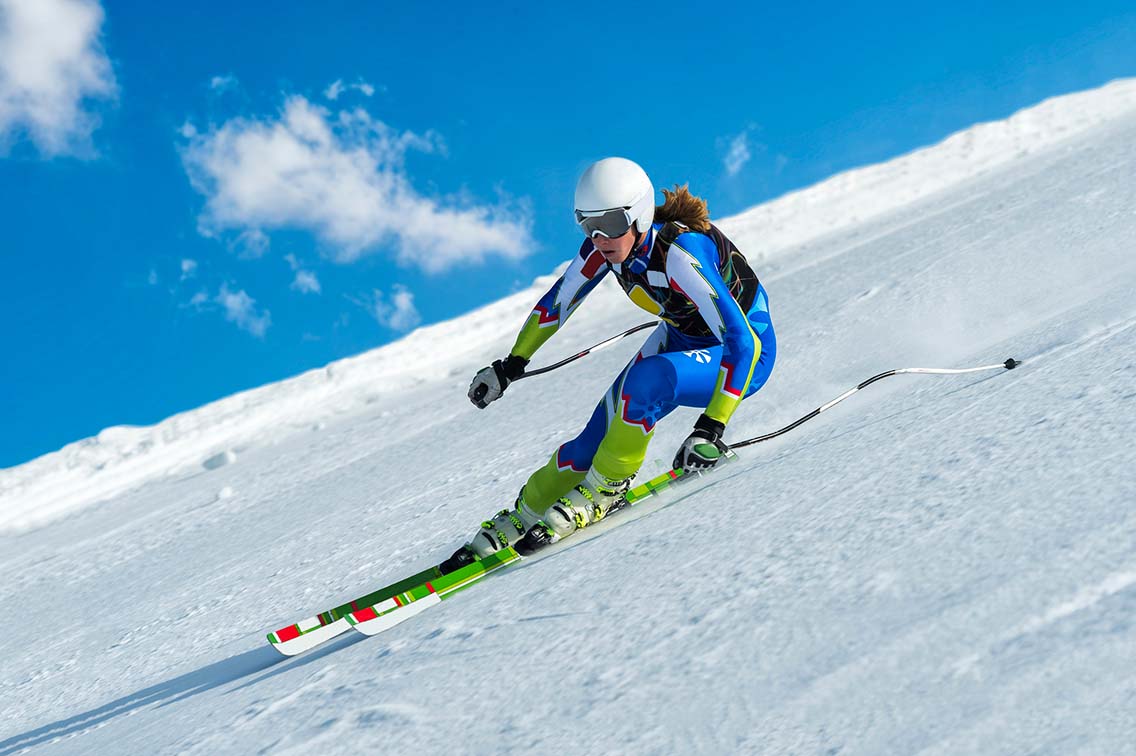 Female ski racer descending slope