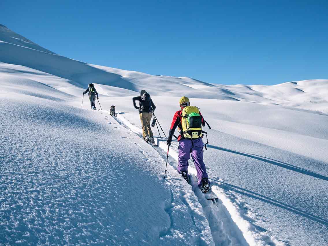 3 ski tourers skinning uphill
