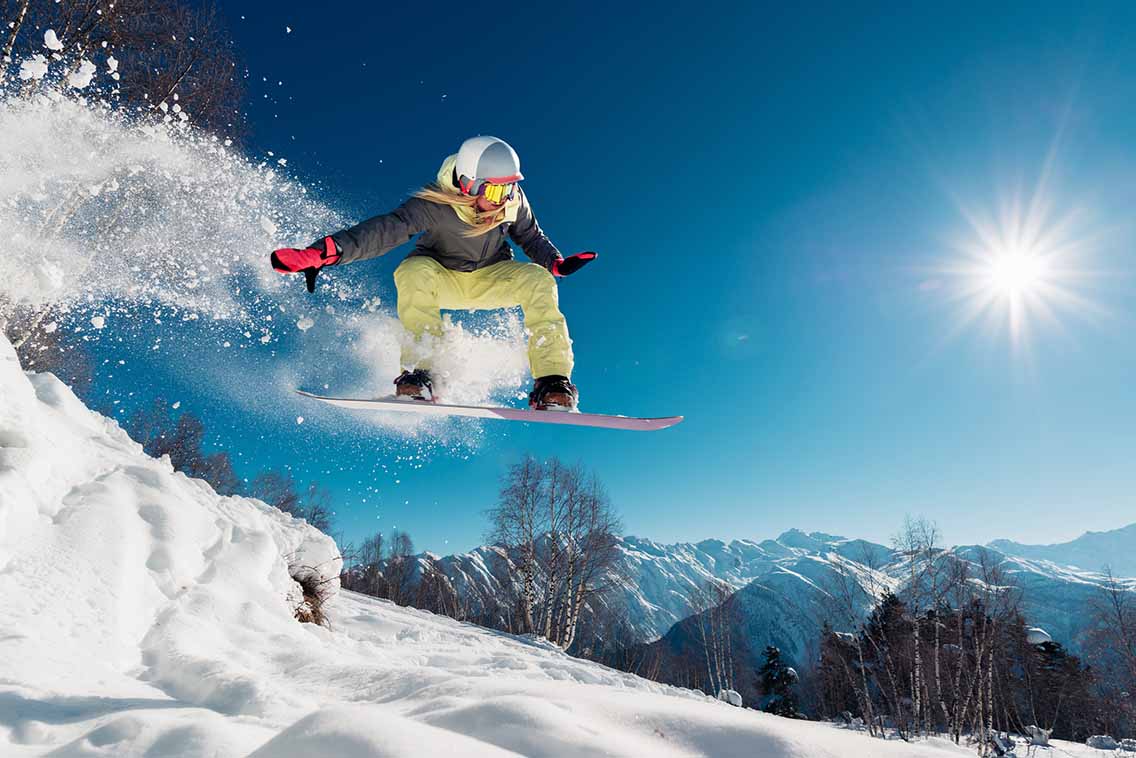 Female snowboarder mid-air jump