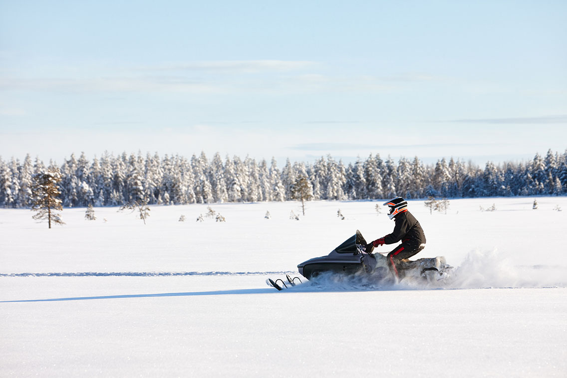 Snowmobiler on flat snow terrain