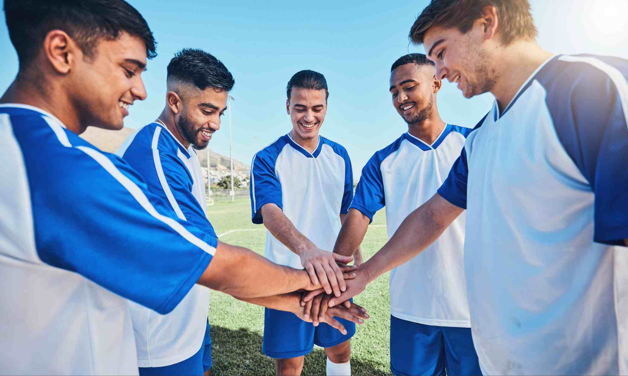 Football team mates putting hands in