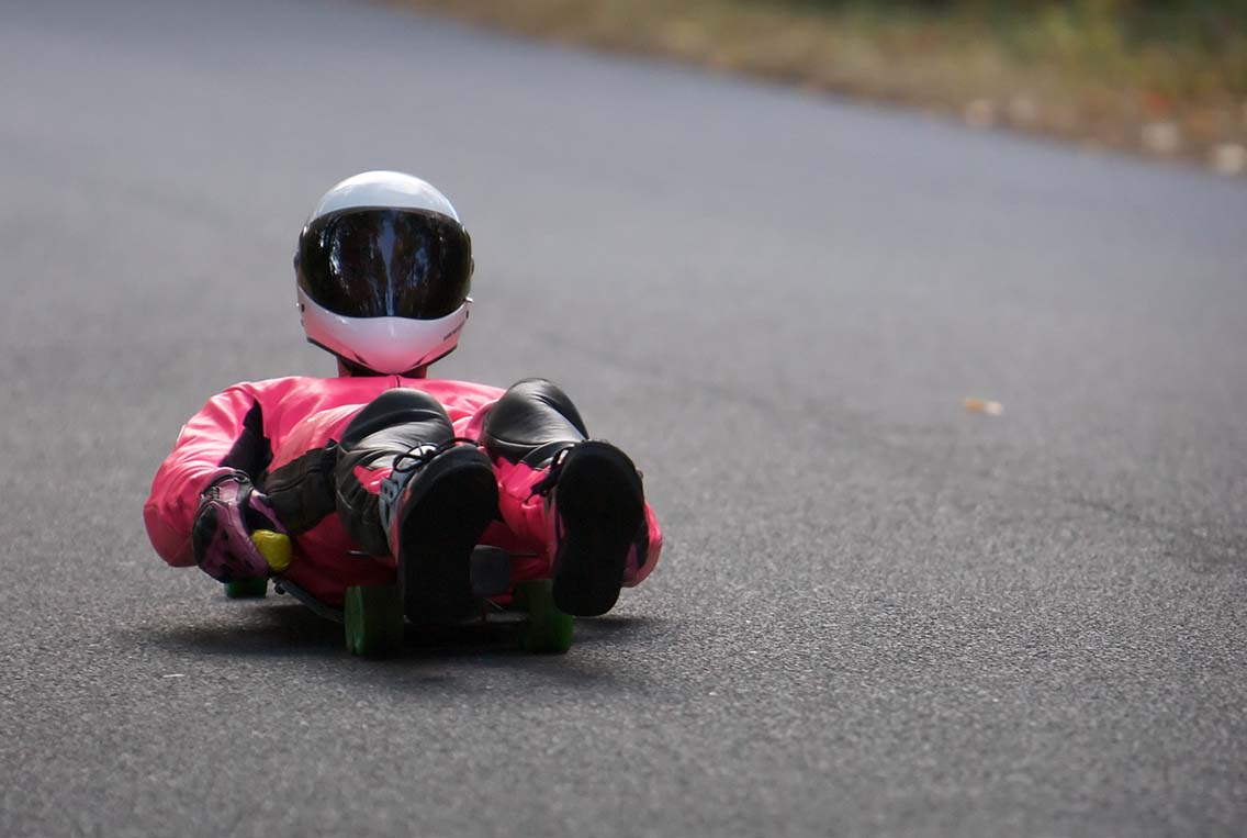 Man on street luge with helmet