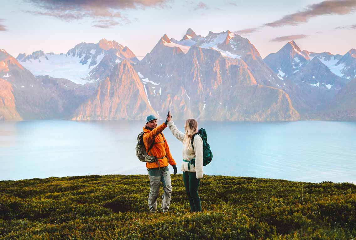 2 hikers doing high 5 with mountain backdrop