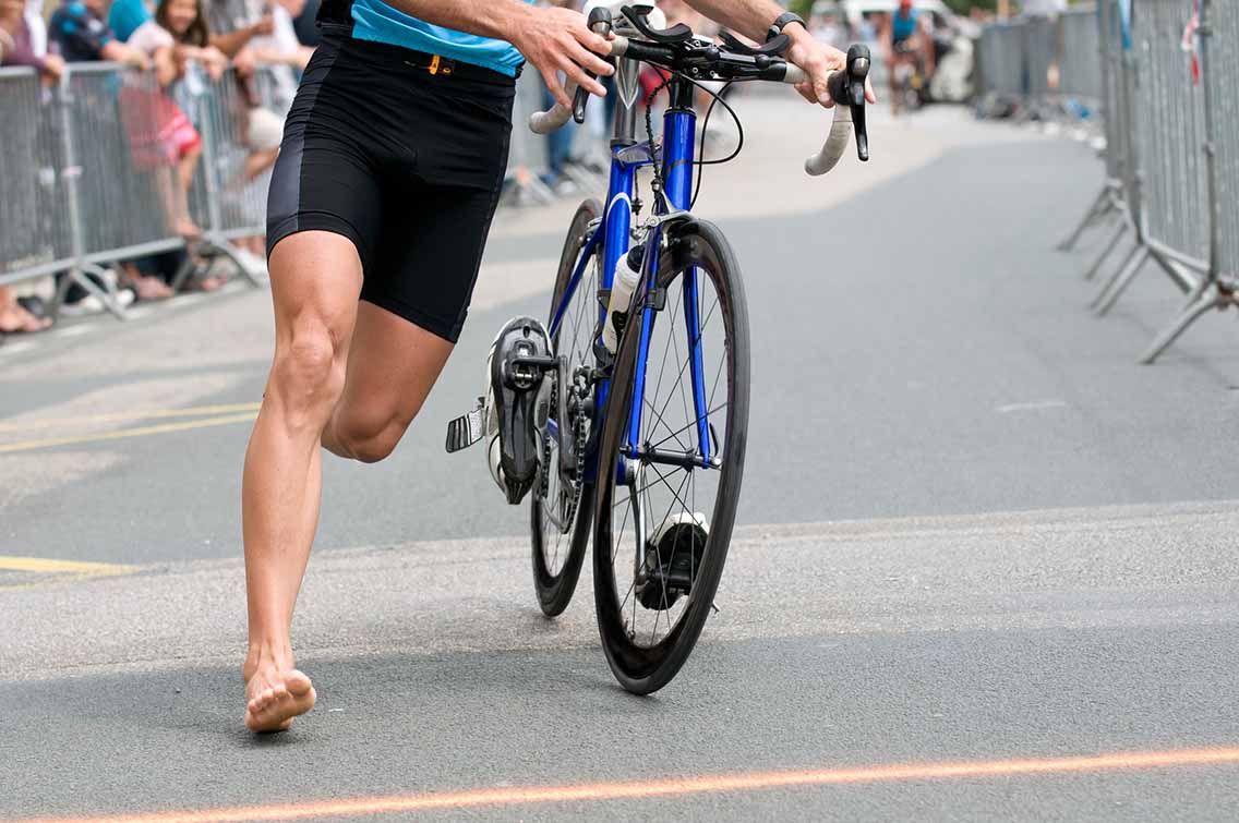 Man in triathlon transition onto bike