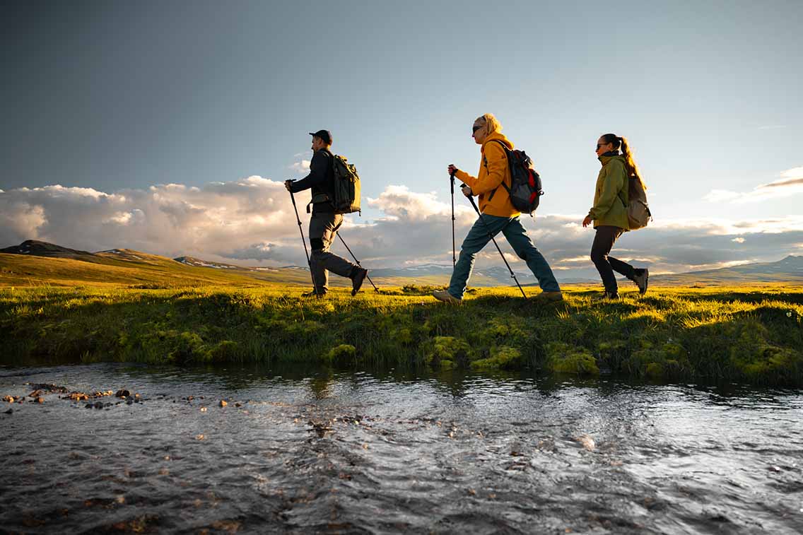 Hikers walking beside lake woht backpacks