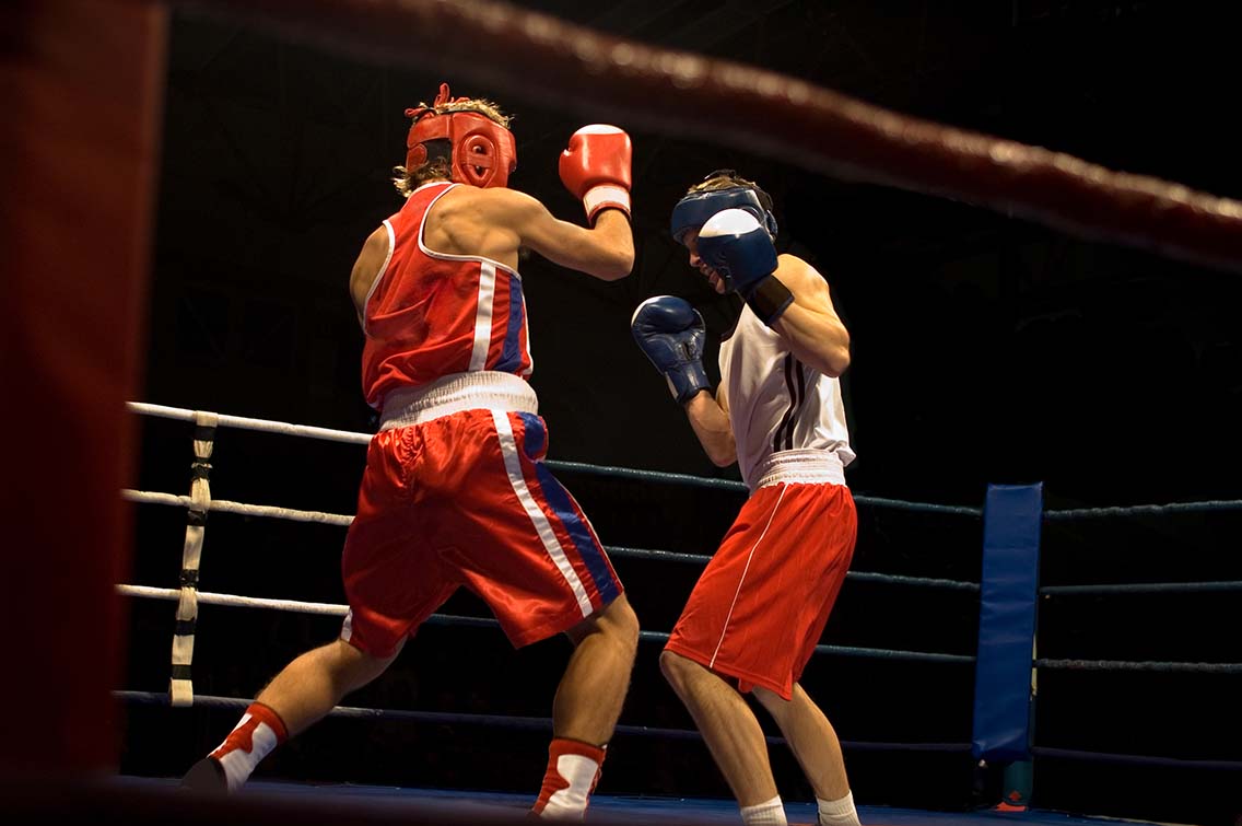2 male boxers fighting in ring