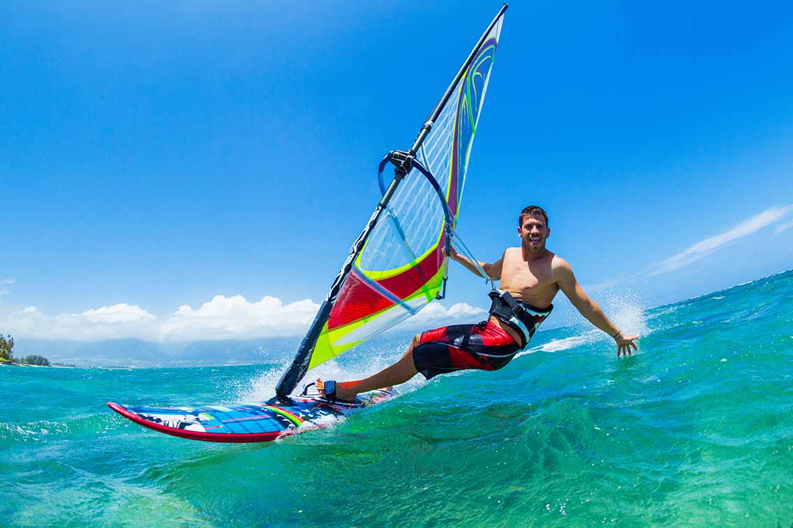 Man windsurfing in clear blue sea