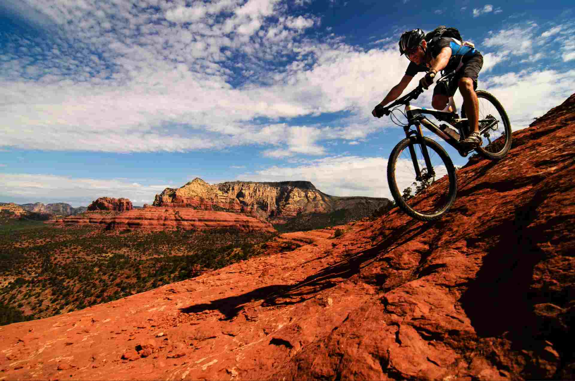 Man mountian biking downhill in canyon terrain