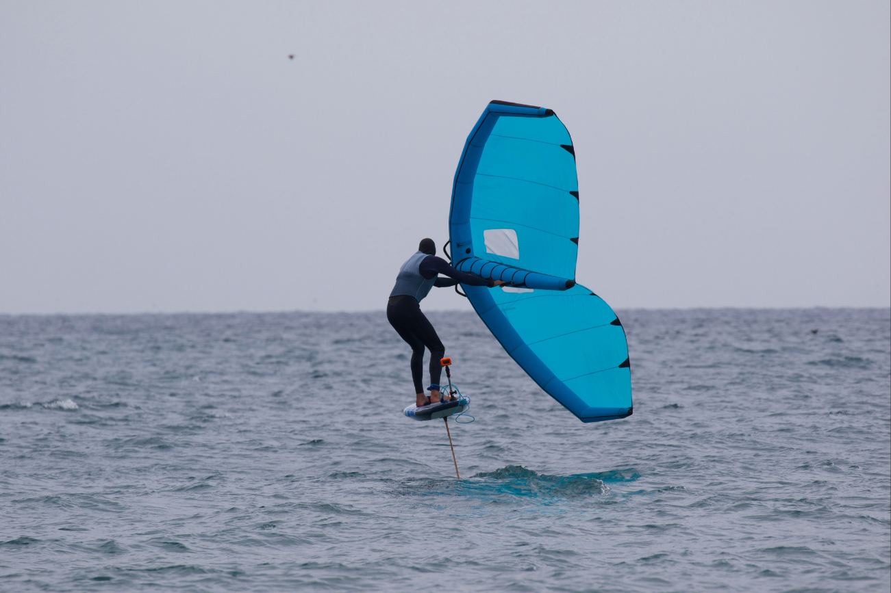 Man wing foiling on sea