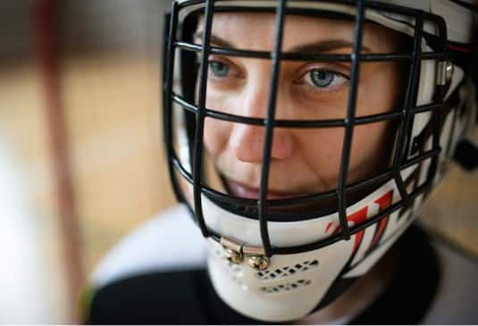 A close-up of woman floorball goalkeeper in helmet