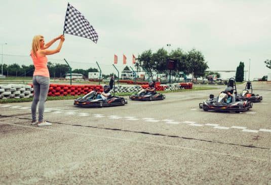 Woman with a flag before go karts start the race