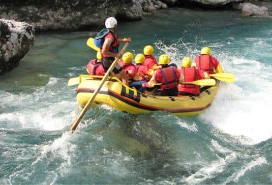 Rafting Insurance Key Benefits r People in yellow raft in a river