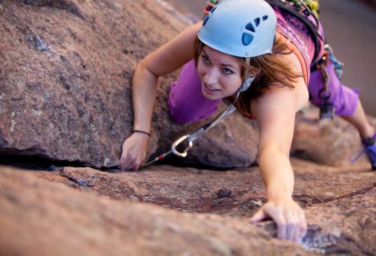 Rock Climbing Key Benefits Young woman leading a climbing route