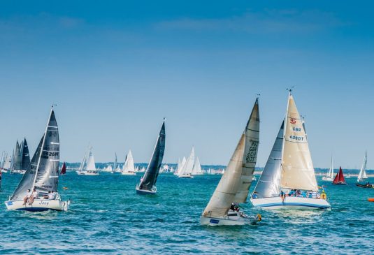 Sailing close to shore Many sailing boats at sea