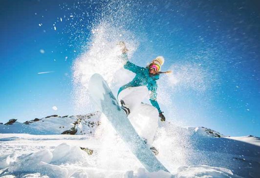 Snowboarding-BottomImage Woman jumping on a snowboard