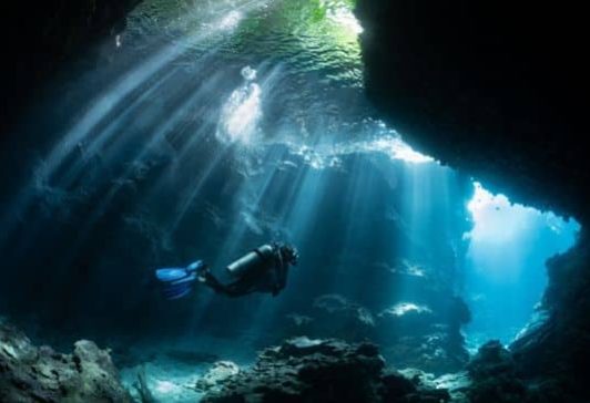 What does Adventure Travel Cover c Scuba diver in shallow lagoon