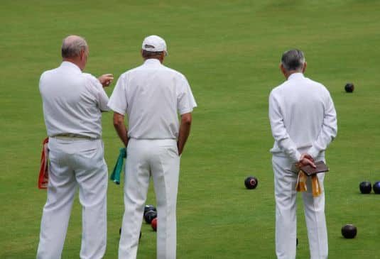 Elderly people playing bowls