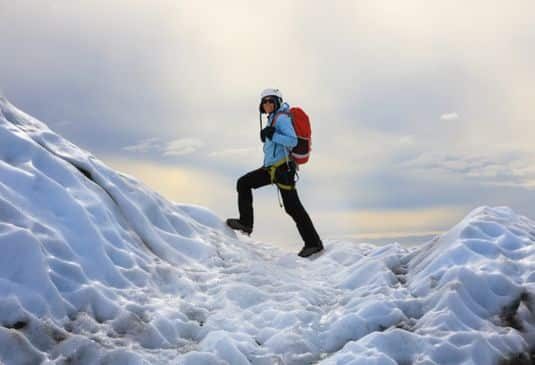 Man walking up a glacier