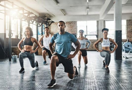 A group of young people doing lunges together