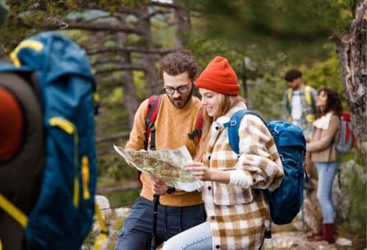 Young couple of backpackers examining the map