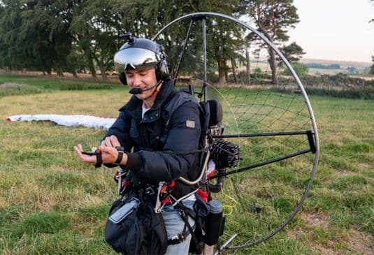 Why Paramotoring Insurance cr Man making last minute checks, as he prepares for take-off on his paramotor