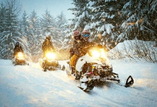 Snow mobile in blizzard through the woods