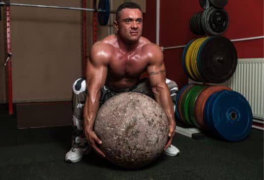 Strongman trying to lift a huge rock