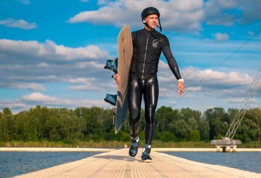 Why Wakeboarding Insurance cr wakeboarder walking with board along pier