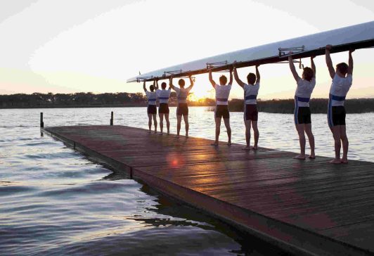 Men holding canoe over heads